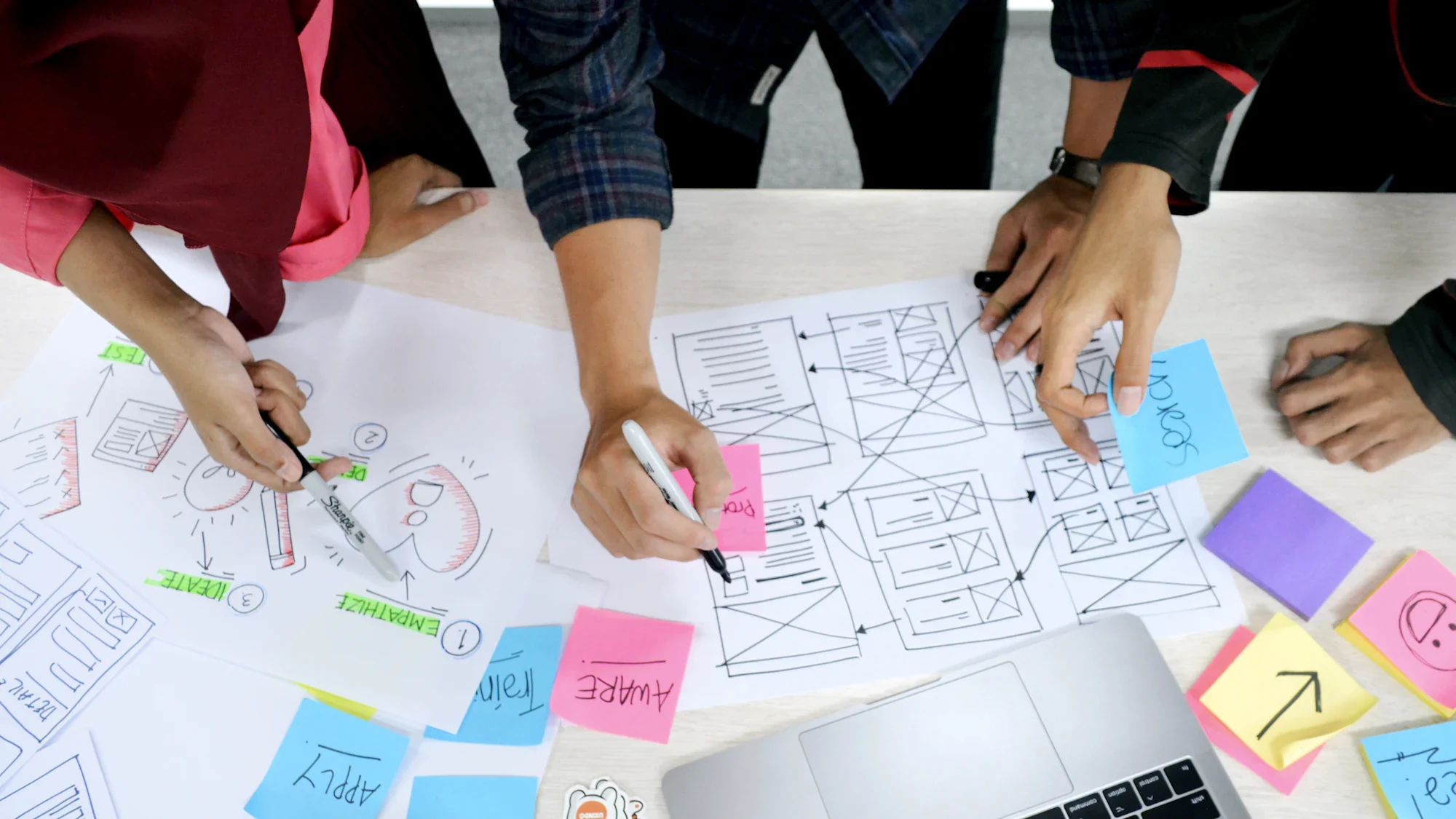 A team sketching layouts on paper covered in sticky notes