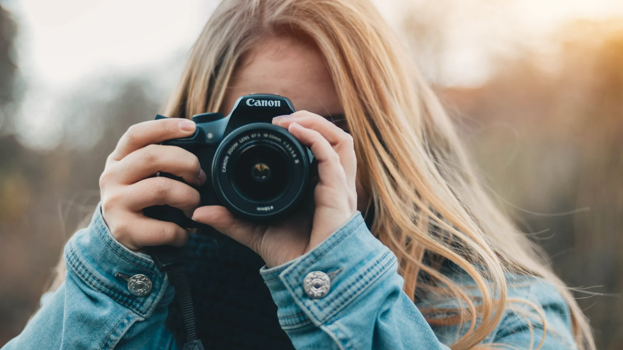 A woman holding a camera up to her face