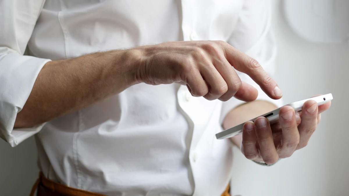 A man in a white shirt tapping the screen of a smartphone