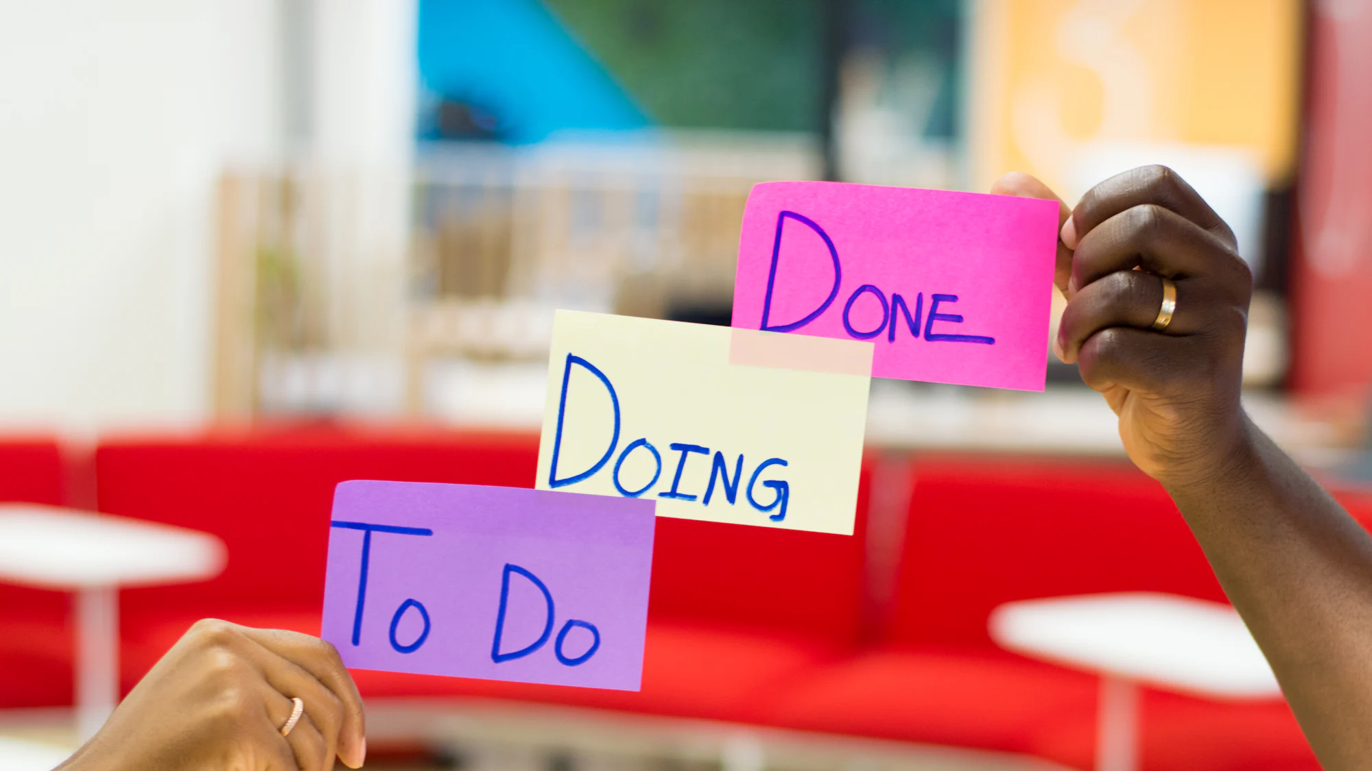Sticky notes reading To Do, Doing and Done held up to a wall