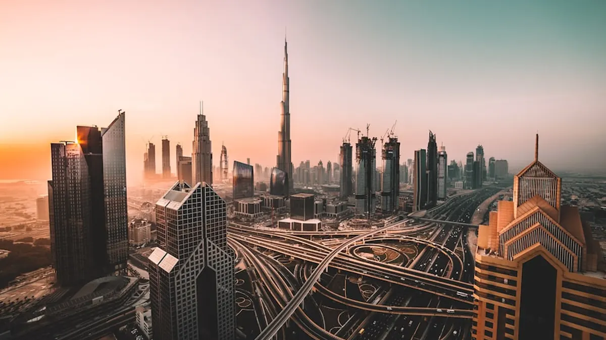 The Dubai skyline at dusk with city lights coming on