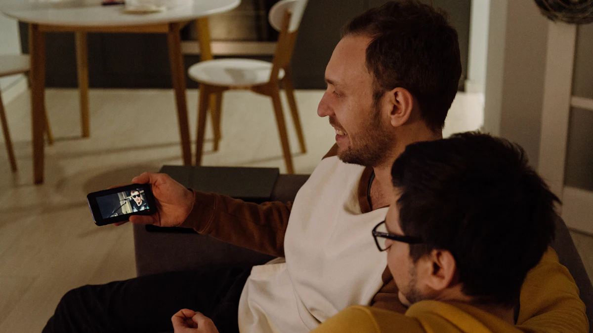 Two men on a sofa watching a video on a smartphone held sideways